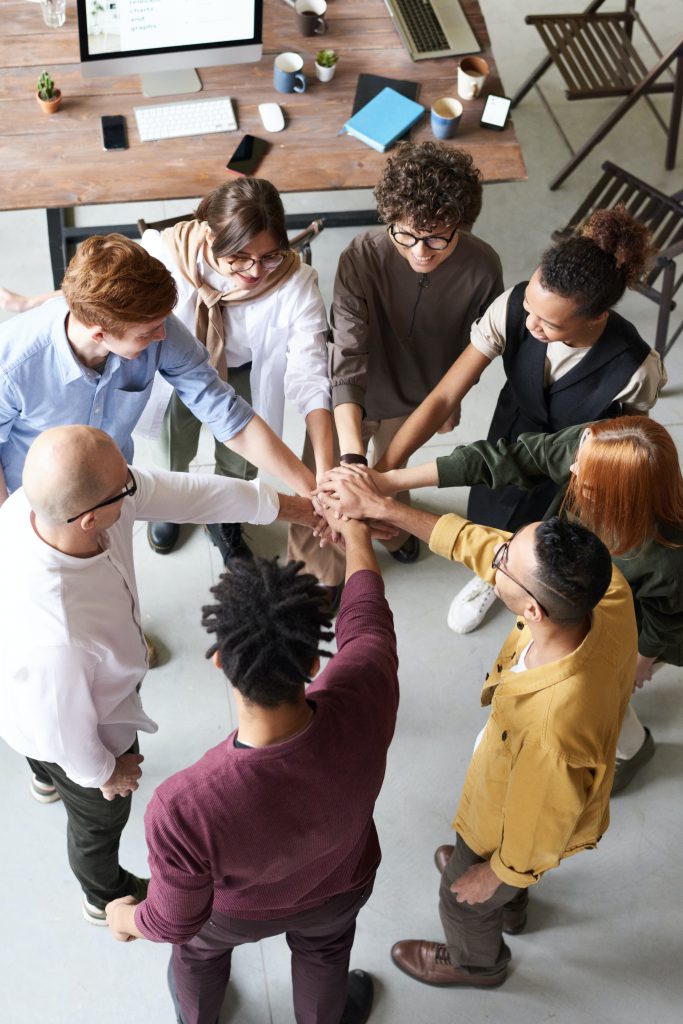 diverse team joining hands together